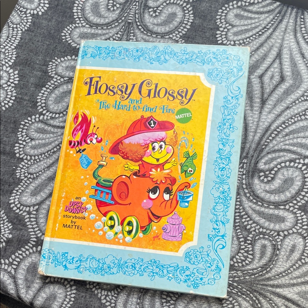 Mattel Flossy Glossy and the Hard-to-Find Fire Storybook - Orange and Blue Cover